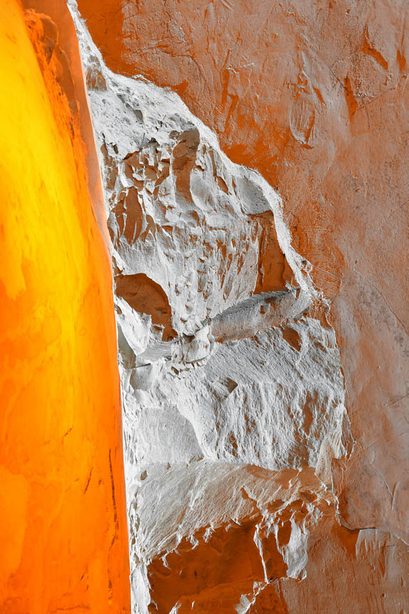 Contrast between the rough rock of the Crayères walls and the orange light that illuminates this heritage.